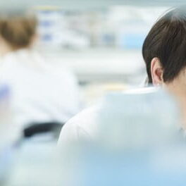 healthcare lab technician using microscope